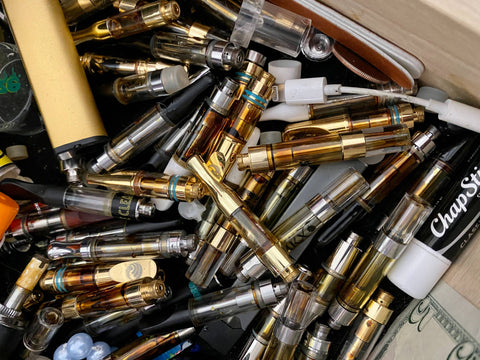 A big pile of old empty 510 thread oil cartridges are stashed in a drawer.