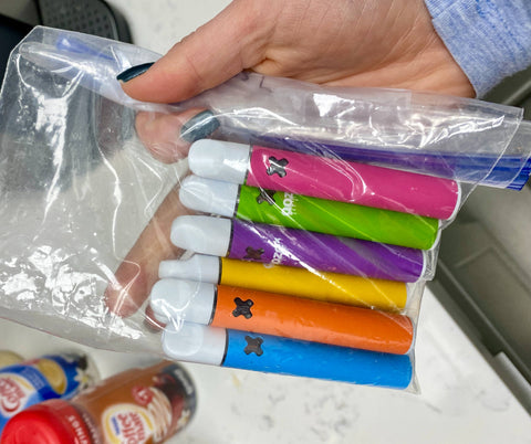 6 Empty OozeX disposable THC vapes are in a plastic ziploc bag ready to be disposed of.