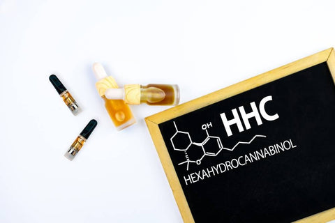 A small chalkboard in the lower right corner says HHC Hexahydrocannabinol with the chemical structure. To the left, two tincture bottles and two 510 cartridges lay on a white background.