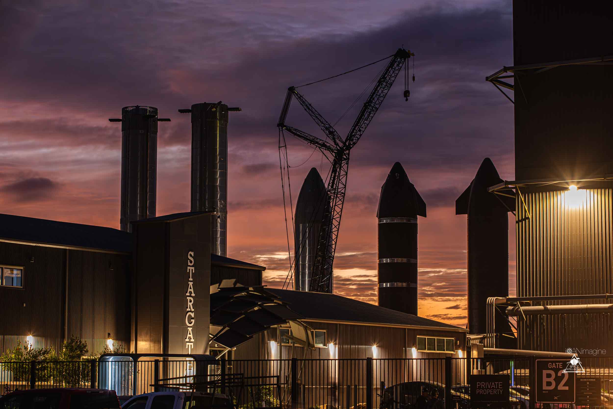 Illuminated Stargate building at dusk with the Rocket Garden in the background.