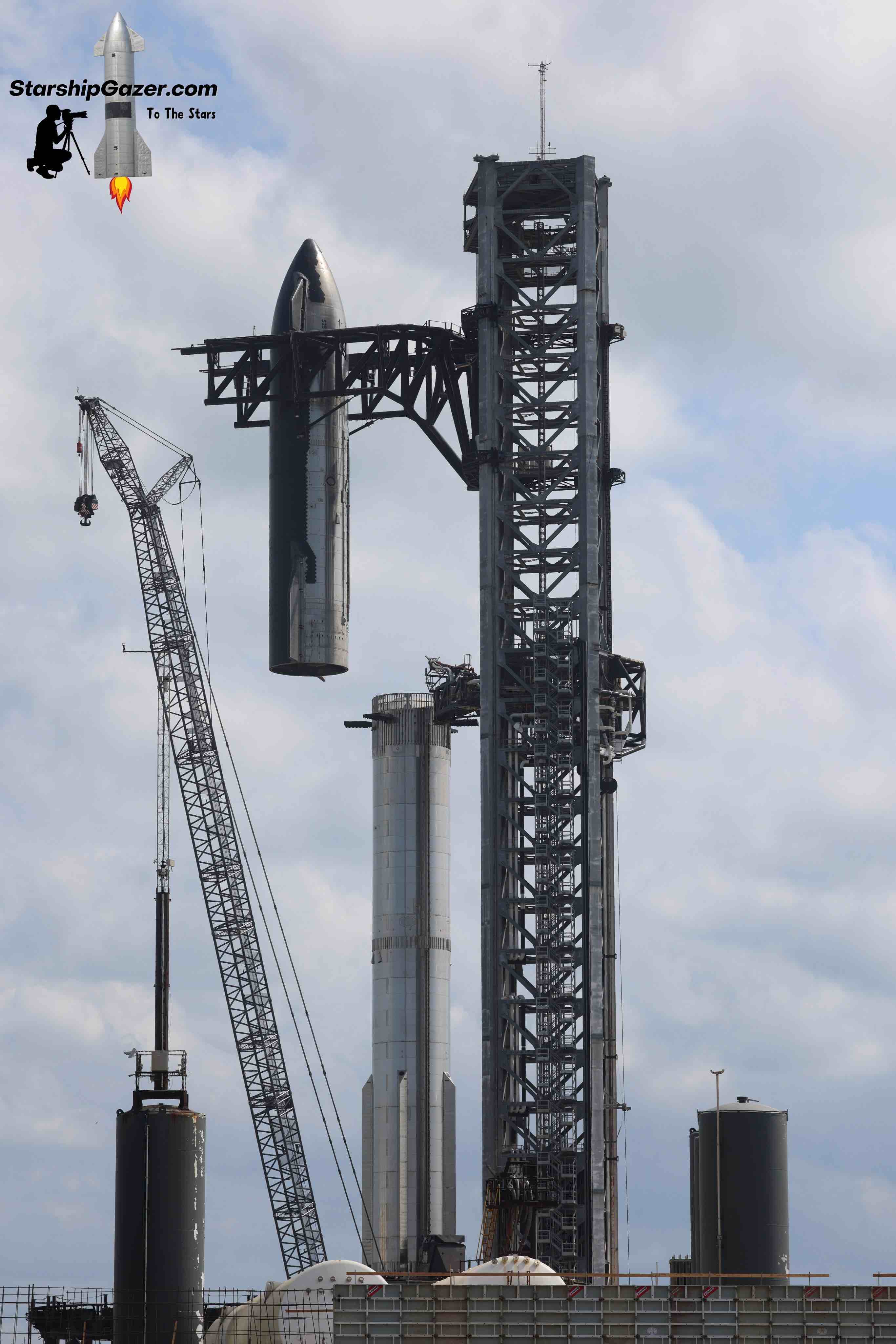 The SpaceX Orbital Launch Tower at Starbase stacks a Starship onto a Booster.