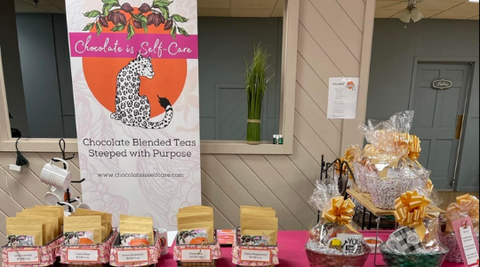 Pull up banner with chocolate is self-care with pouches of tea in baskets