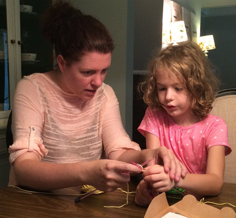 Kari teaching a young girl to knit