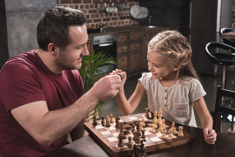man teaching chess to kid