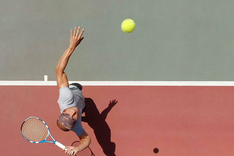 Ein Tennisspieler, von oben fotografiert, beim Aufschlag.