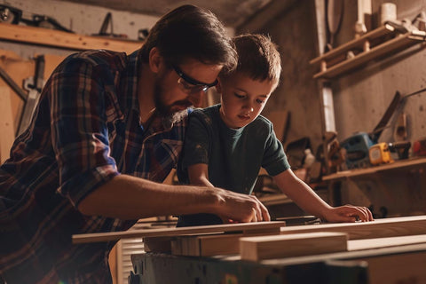 Ein Vater und sein Sohn in der Holzwerkstatt beim Heimwerken.