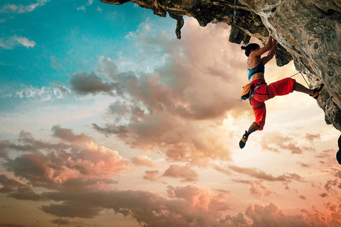 Eine Frau klettert an einem Bergüberhang.