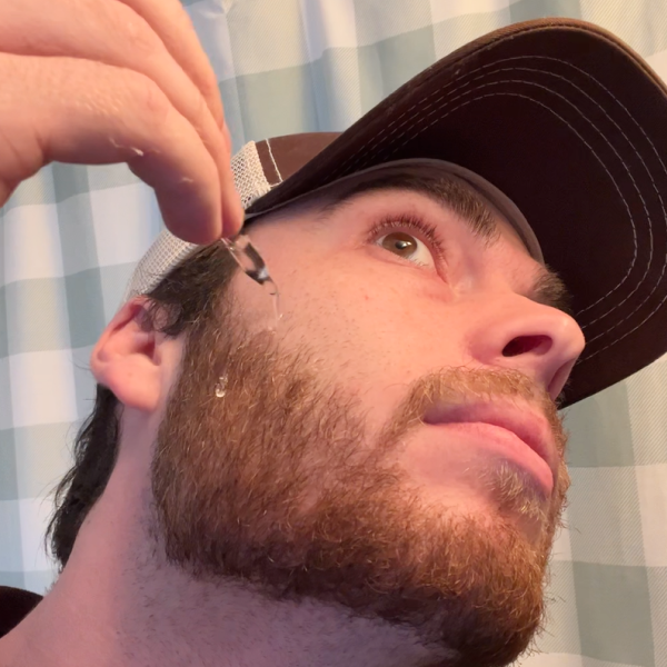 Closeup of a man applying a beard oil
