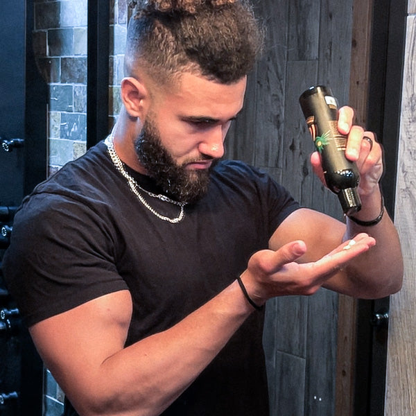 A man pouring a bottle of beard conditioner