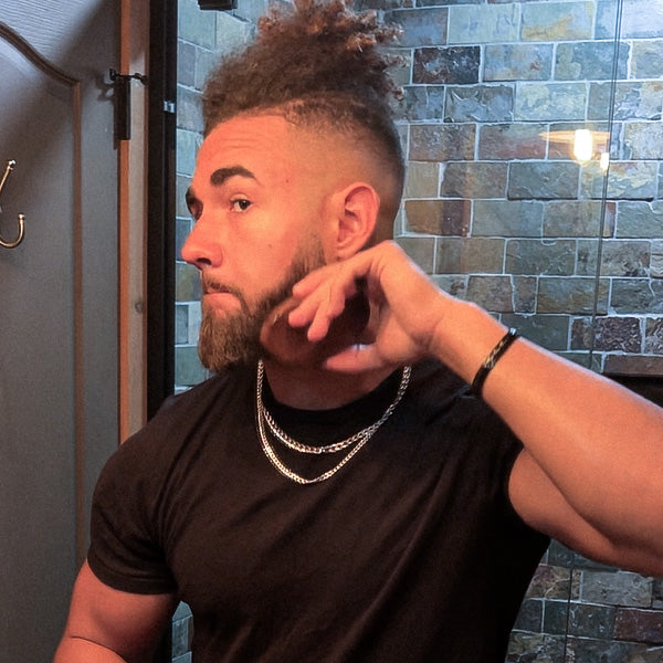 A man grooming himself with a beard brush