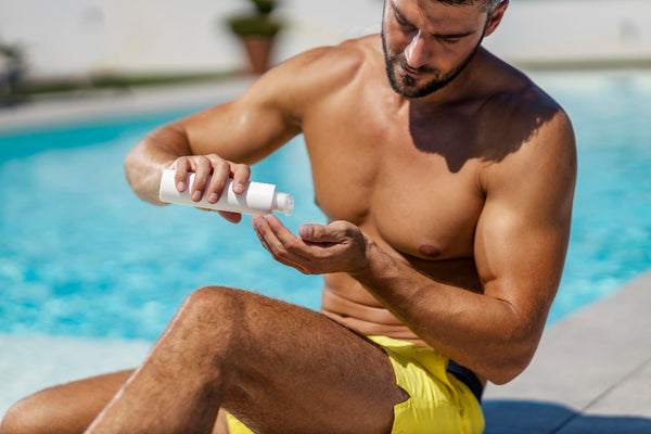 man applying sunscreen on his face