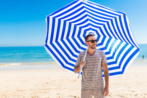 man using umbrella to protect his beard from the sun