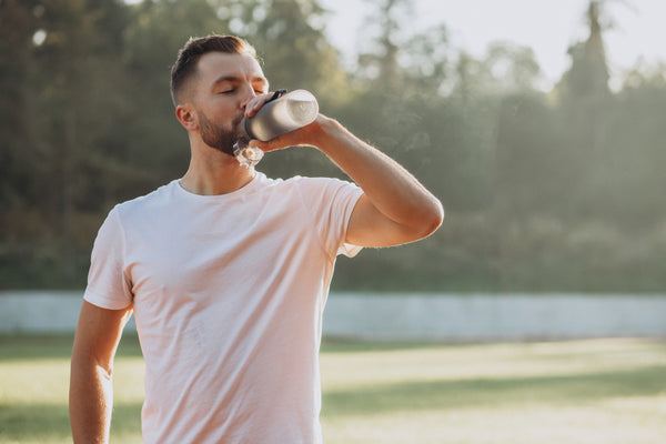 man drinking water during summer