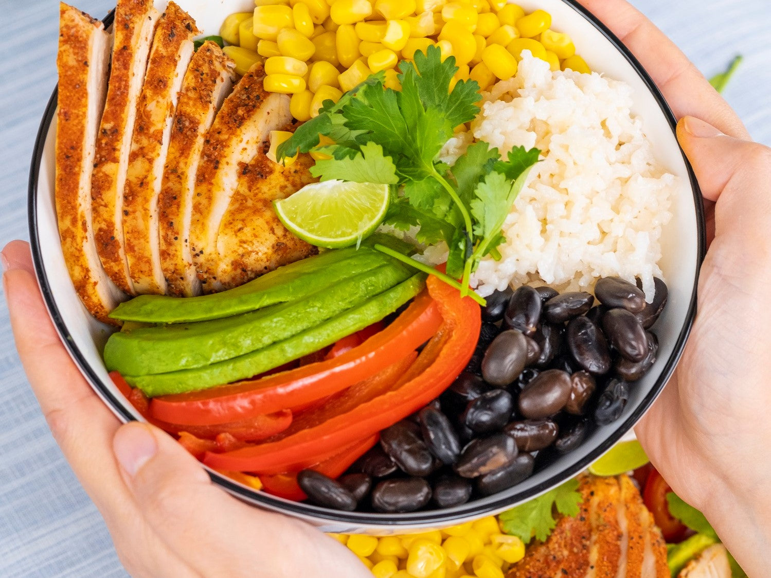 Holding Chicken Burrito Salad Bowl on hands