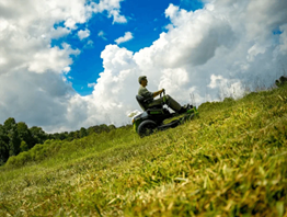 Man operating Greenworks 60V Battery Powered Electric ZTR Lawn Mower on lush green lawn, powered by four brushless motors and six 60V 8.0 Ah batteries.