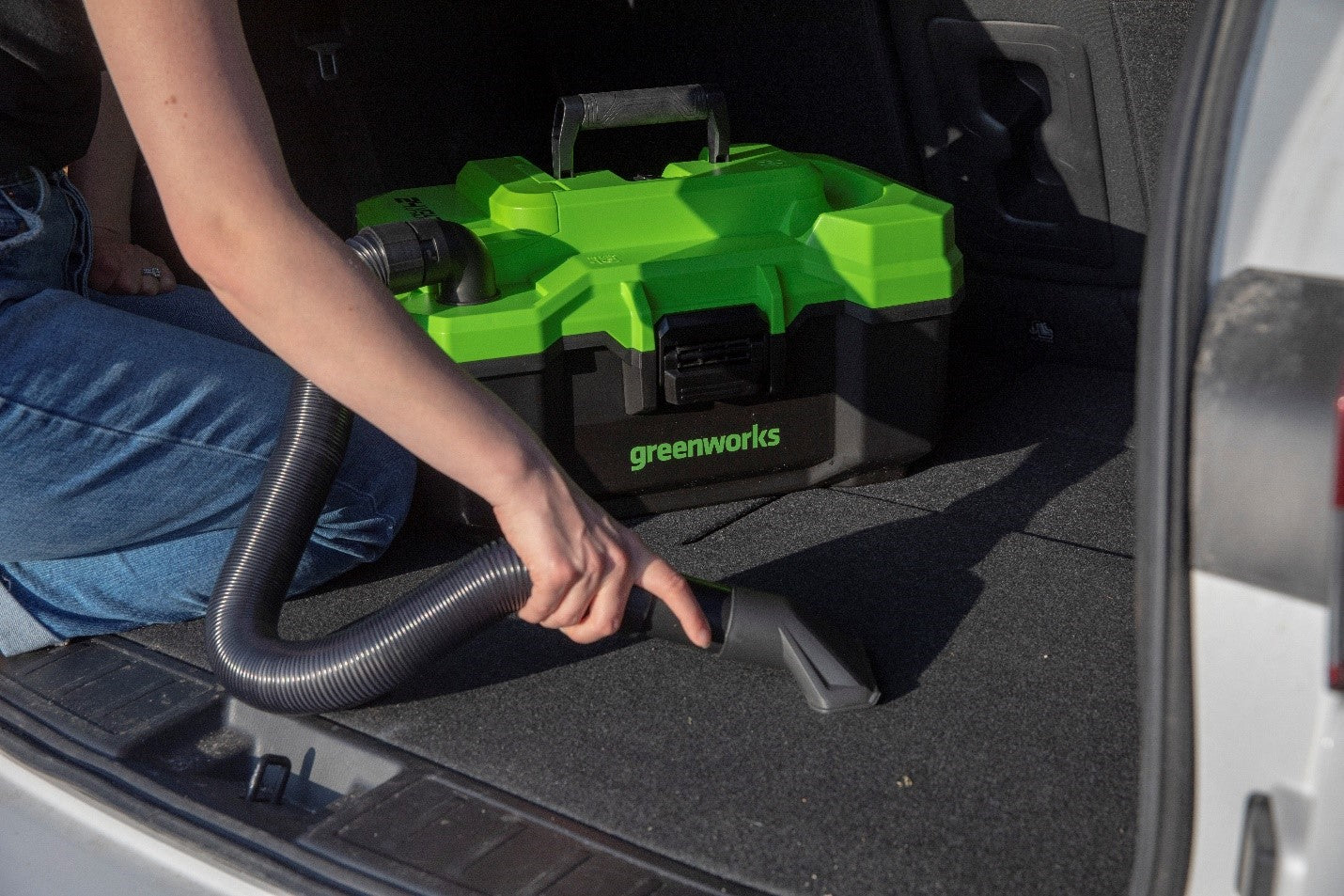 vacuuming out the back of a car