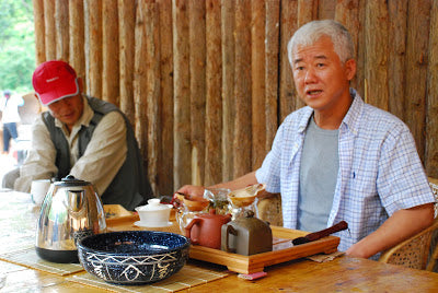 Zhu Ge serving tea at Zhi Zheng's maocha processing facility on Nannuo