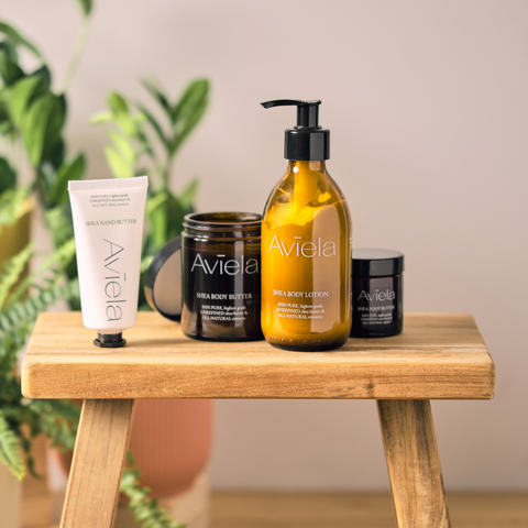 Image of Aviela skincare on a wooden table with plants in the background