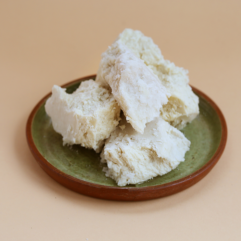 raw pure shea butter in it's natural form displayed on a plate