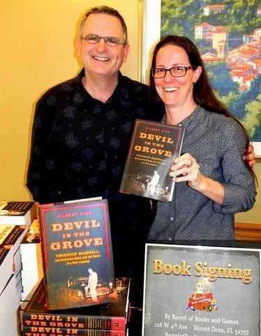 Crissy Stile, owner of Barrel of Books and Games, stands next to Gilbert King, author of "Devil in the Grove" at a book signing hosted by the store.