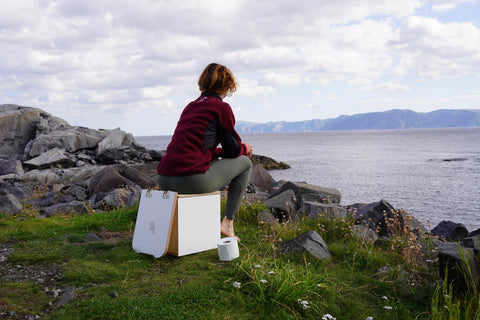 woman sitting on composting toilet