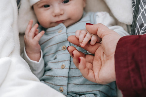 neugeborenes baby hält die hand der mutter