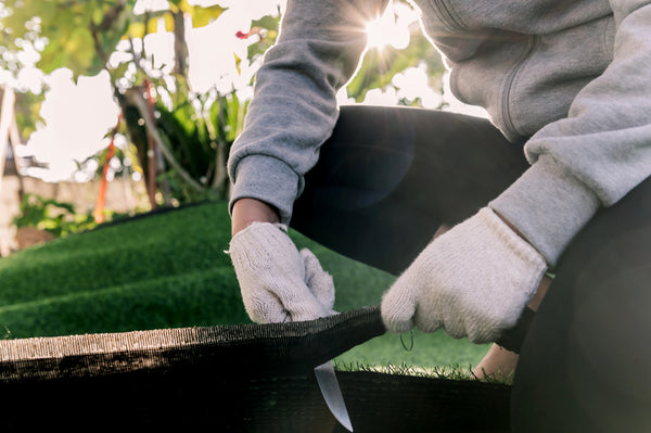 laying out fake grass roll and decoration for DIY green garden