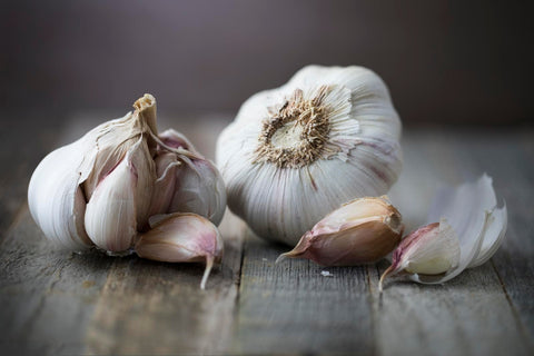 Garlic heads and cloves on wooden table