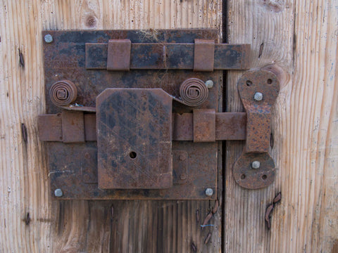 A rusty metal lock to secure chicken coop against predators