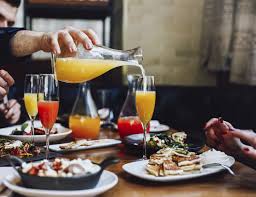 Man pouring more mimosas during brunch