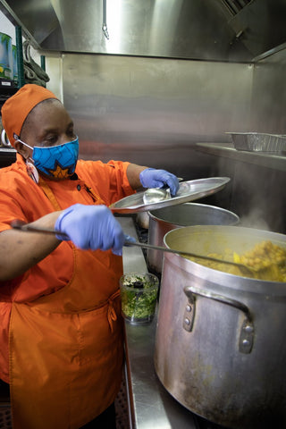 Chef Ann Cooking Curry Potatoes and Chana at Cocobreeze Caribbean Restaurant and Bakery