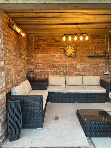 An outdoor space with a couch and a KMH-30 3KW Infrared Wall Mounted Outdoor Garden Heater attached