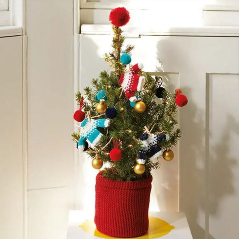 A tiny Christmas tree decorated with knitted jumpers
