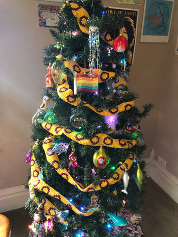 A customer's Christmas tree decorated with a yellow and purple Intersex Pride tree scarf