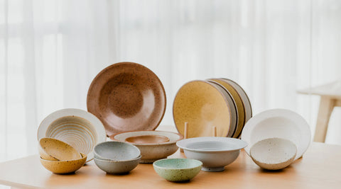 Colourful plate and bowls displayed as a collection on a table.