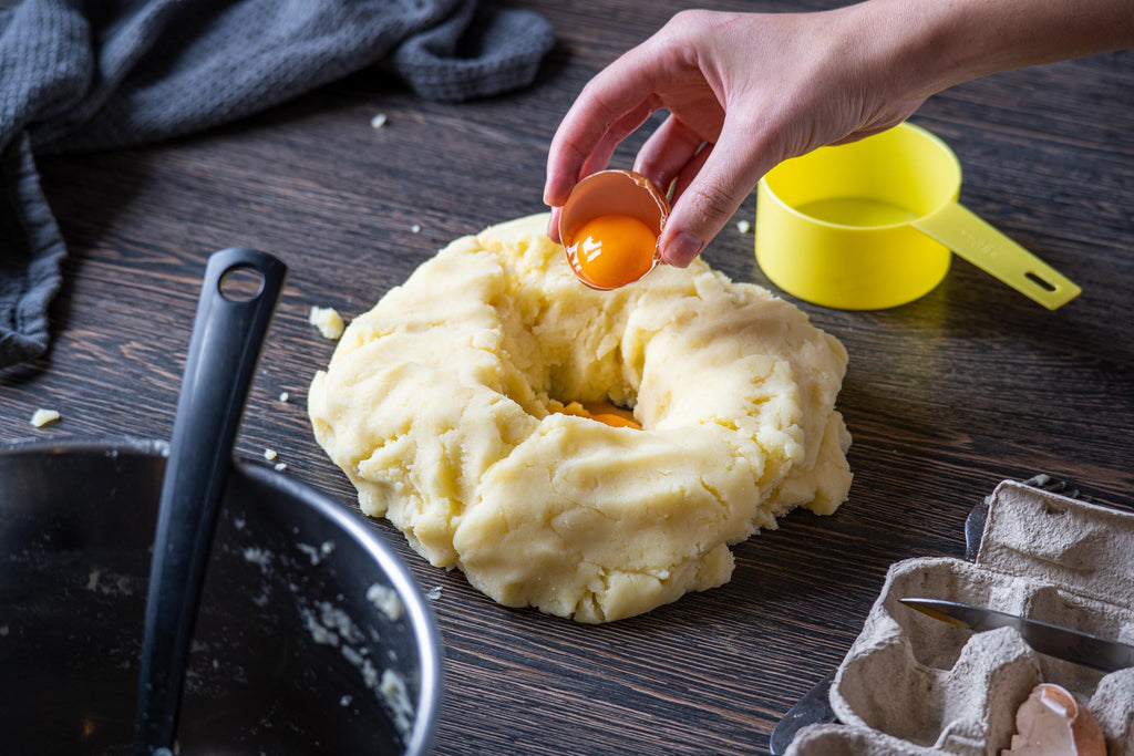 Adding-egg-to-the-dough-while-making-food