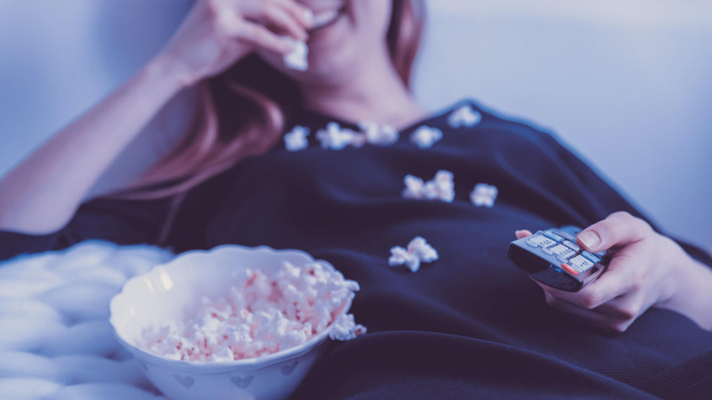 A-woman-laughs-out-while-eating-popcorn-and-watching-a-movie