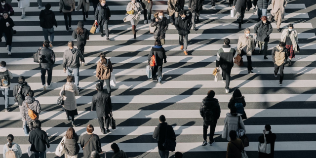 A crosswalk with a lot of people walking