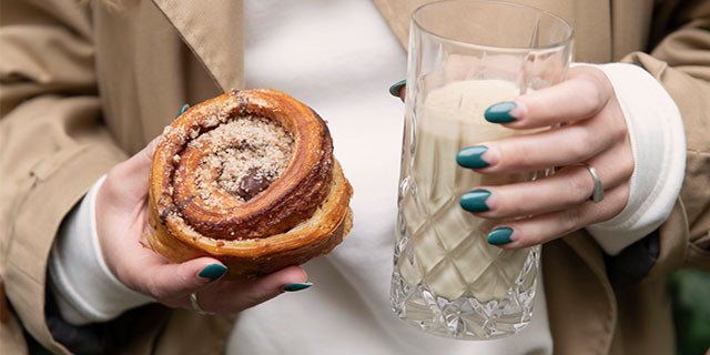 cinnamon roll with a glass of Golden Milk