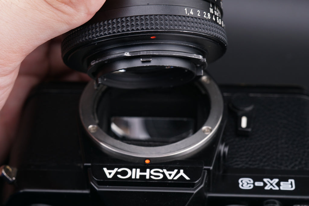 attaching a lens into a Yashica FX-3 camera