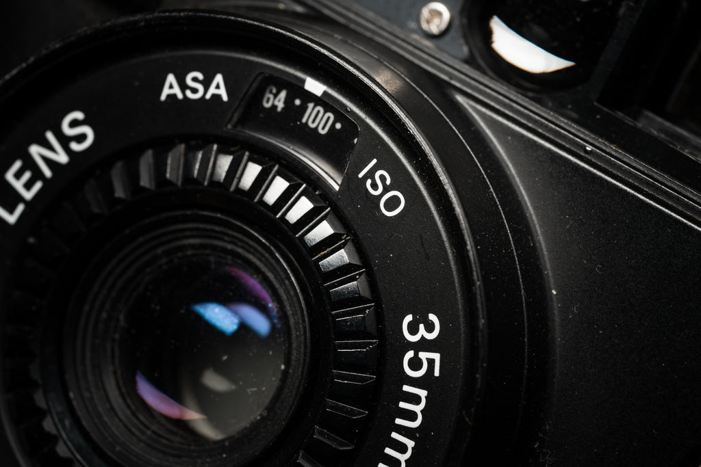 closeup of a nikon l35af camera and its iso control