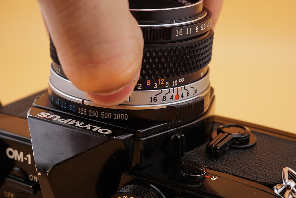 closeup of an olympus om-1 camera and olympus om lens