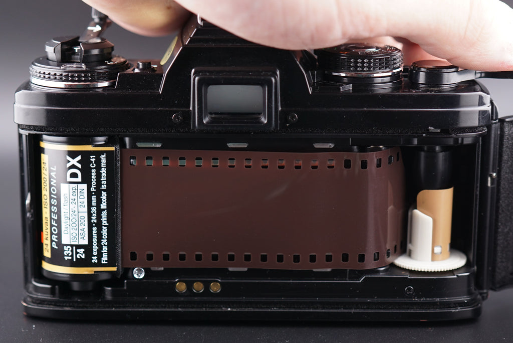 inserting the film into a Minolta X-700 film camera