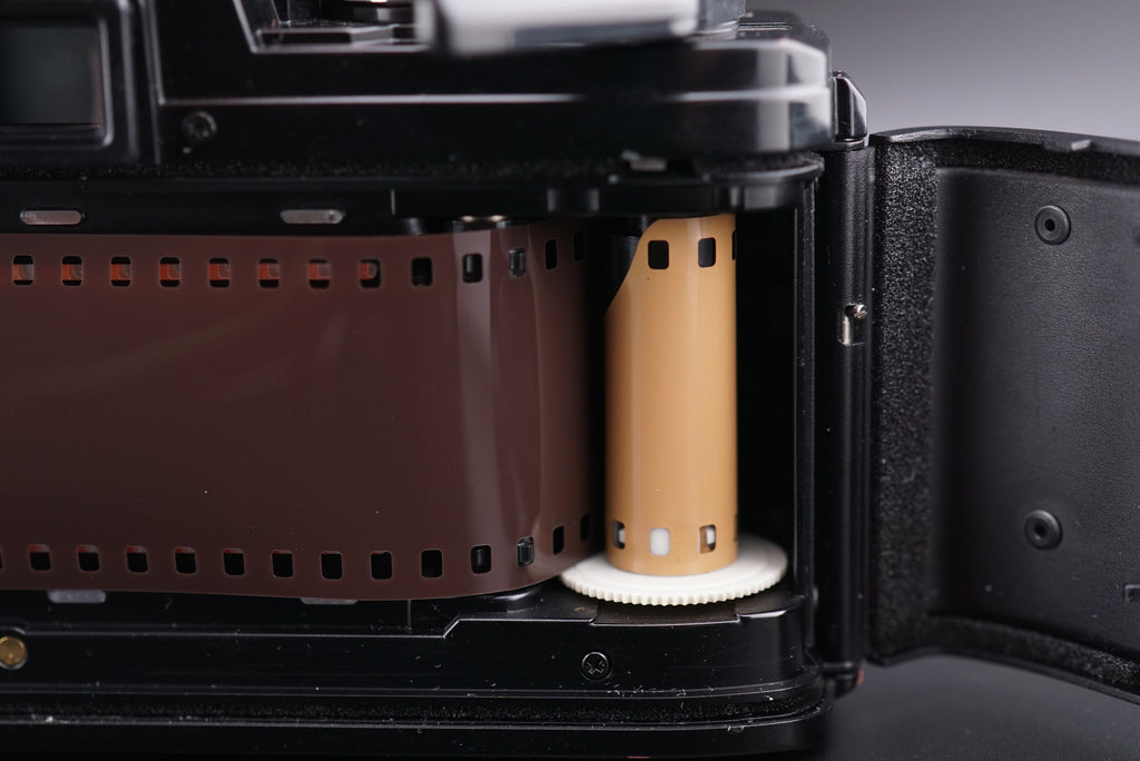 inserting the film into a Minolta X-700 film camera