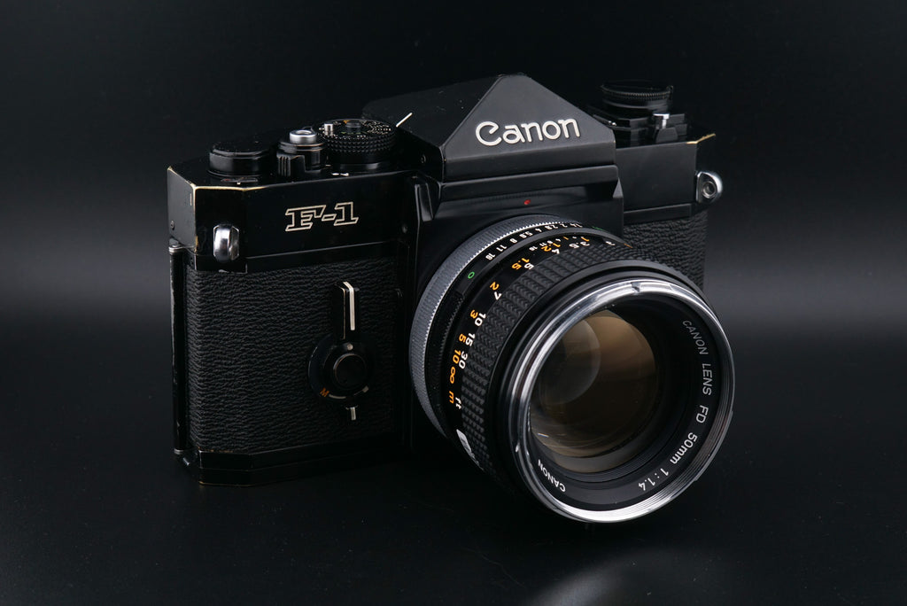 Black Canon F-1 film camera on a black background