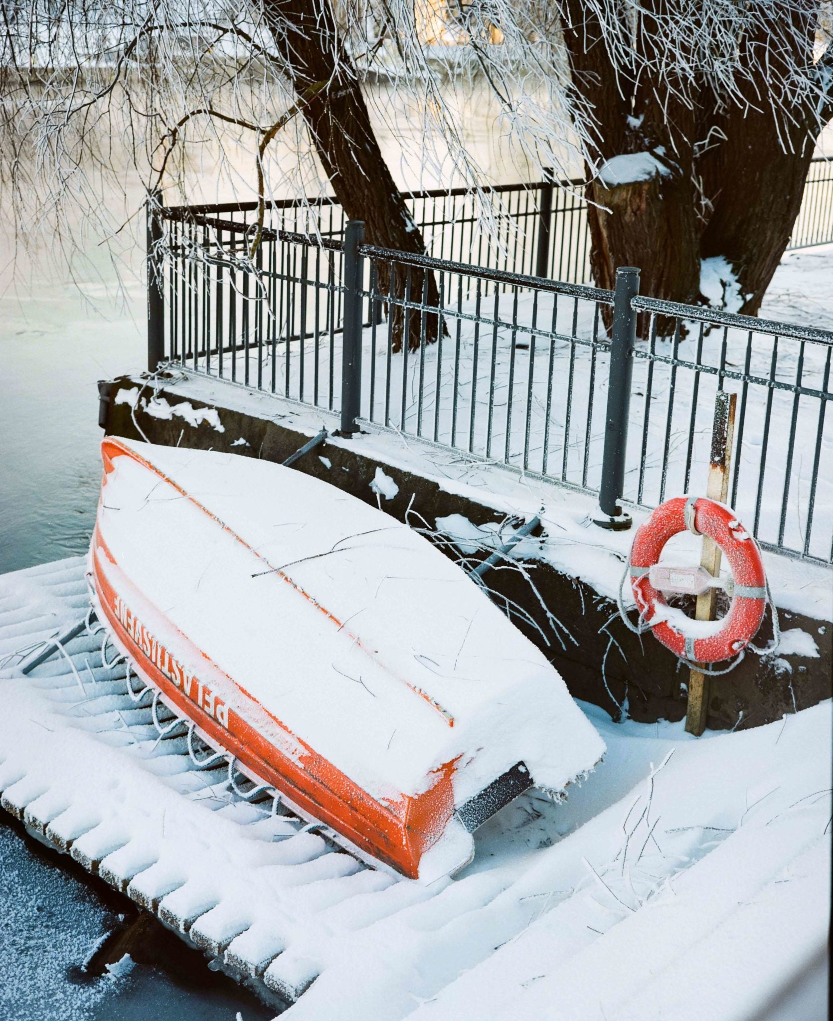 Lifesaving boat upside down on a winter riverside