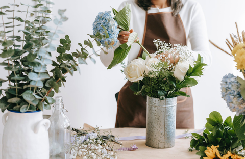 Flourist fixing flowers on a vase