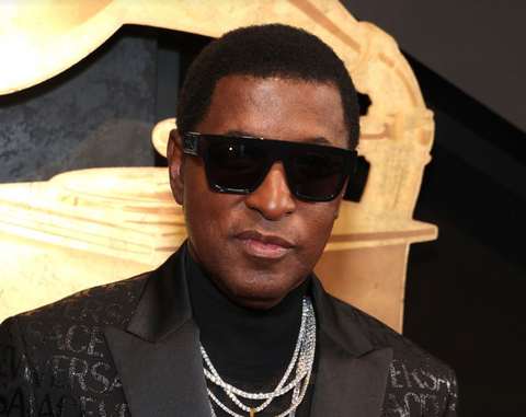 Babyface on the red carpet at the 66th annual Grammy Awards wearing a Versace print suit and black Versace sunglasses