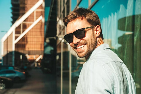 Young man wearing sunglasses in sunny location looking after his eye health