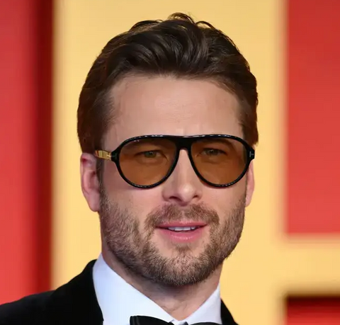 Glen Powell at the Oscar Awards 2024 wearing Tom Ford Quincy TF1080 01E Photochromic sunglasses with orange lenses
